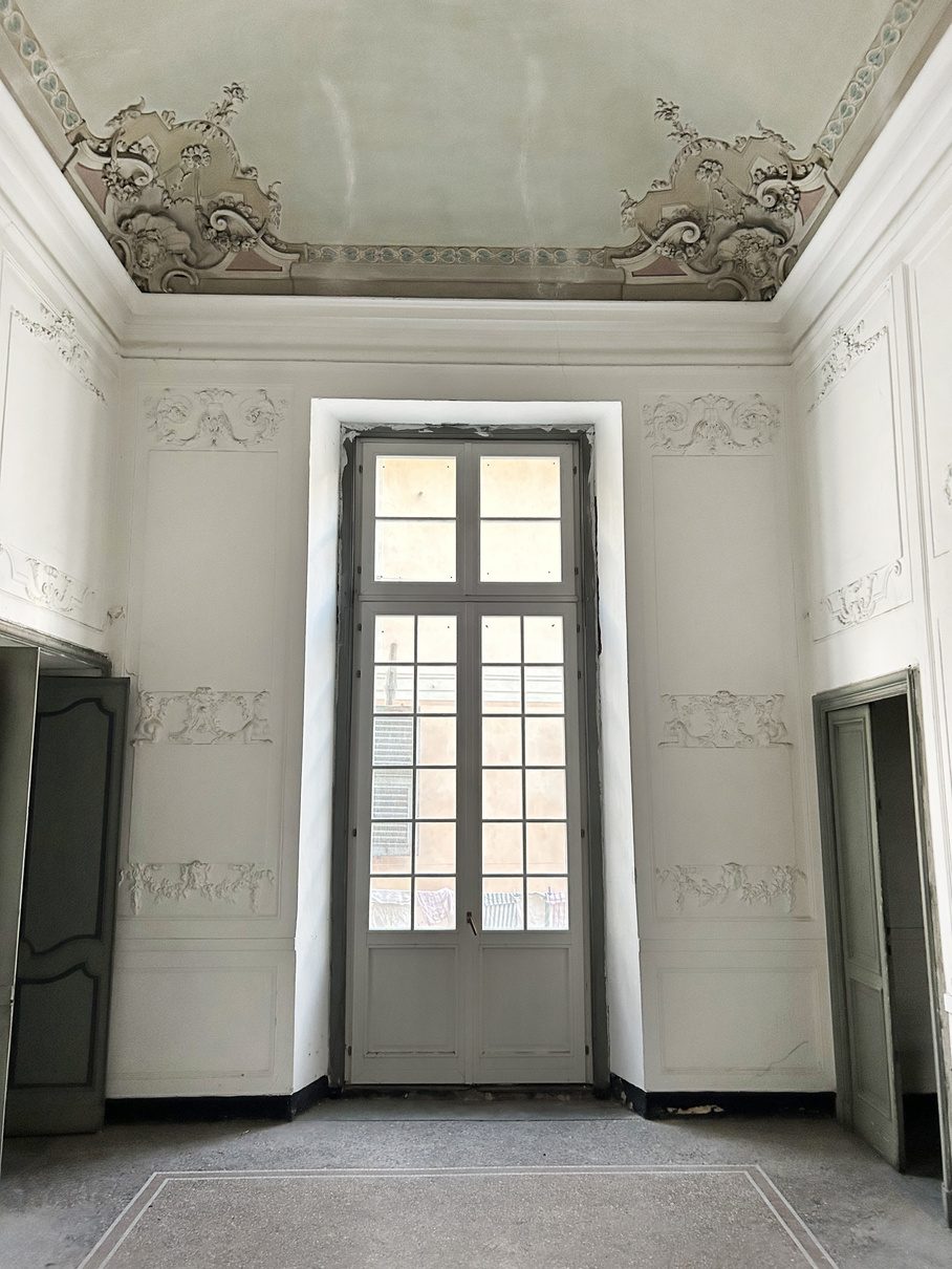 Sala di un piano nobile con soffitto a stucchi, prima del restauro