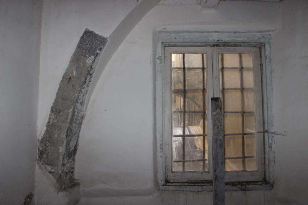 Stone round arch embedded in a first-floor wall